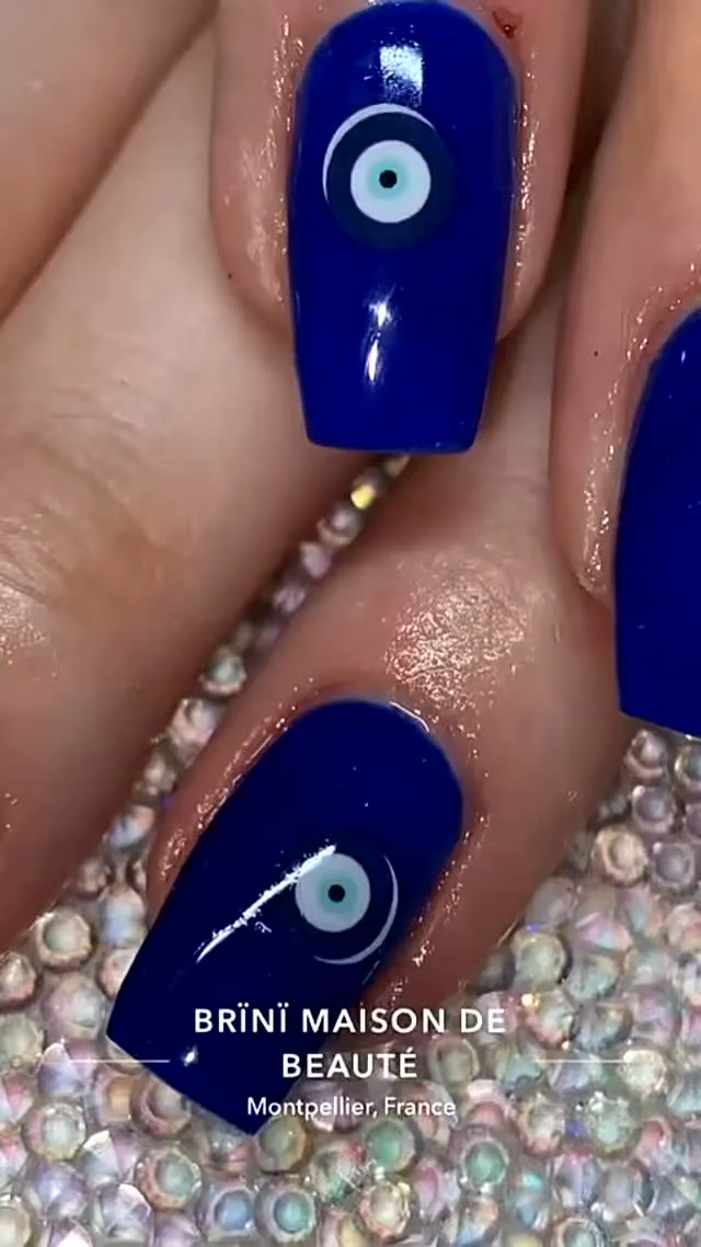 Nail art bleu nazar, petit œil porte-bonheur peint à la main